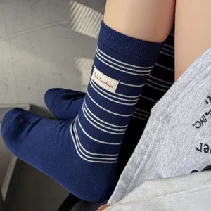 Chaussettes mi-hautes à rayures bleues avec étiquette, style rétro confortable.