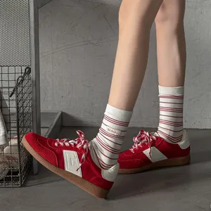 Chaussettes mi-hautes rayées style vintage avec étiquette en tissu, idéales pour look rétro.