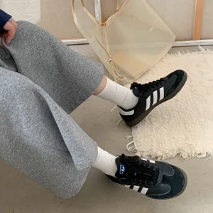 Detail view of comfortable solid color ribbed mid-calf socks paired with casual daily outfit.