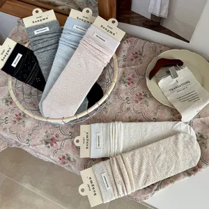 Detail view of hollow solid color pile socks with cloth label and cute mesh design.