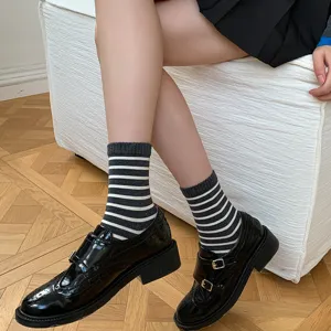 Detailopname van grijze gestreepte sokken voor dames gecombineerd met nette schoenen.
