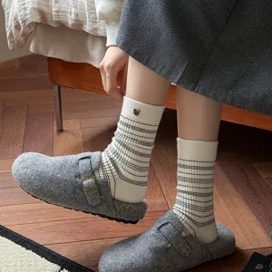 Detailweergave van thermische gestreepte damessokken met schattig berenaccent voor winter.