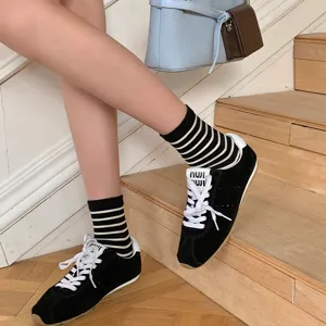 Gedetailleerd shot van stijlvolle zwart-witte gestreepte sokken gecombineerd met schoenen.
