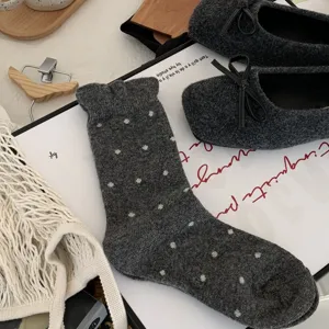 Cozy dark grey wool mid-tube socks with white polka dots, soft winter warm knit detail view.