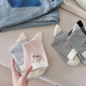 Detail view of women striped mid-tube socks featuring cute dog embroidery and soft combed cotton.