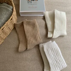 Close-up detail of cozy wool cable-knit winter socks in neutral tones, soft and warm texture.
