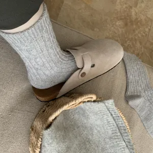 Detail shot of women's wool mid-tube knit socks with classic cable pattern and warm fit.