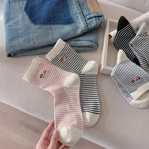 Detail view of striped cotton mid-calf socks featuring cute dog embroidery and comfy fit.