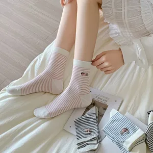 Detail of women's striped mid-calf socks featuring cute dog embroidery and soft combed cotton.