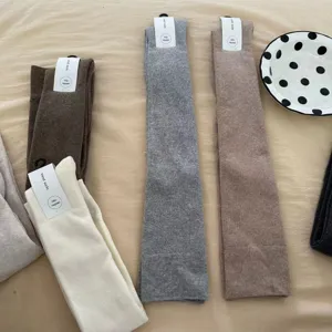 Thickened over-the-knee knit wool socks, soft warm long winter stockings in neutral colors.