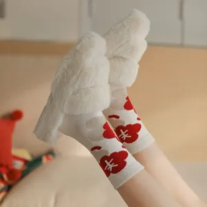 Vue détaillée de pantoufles en peluche d'hiver douillettes avec chaussettes à fleurs rouges