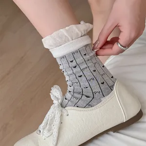 Detailed close-up of women grey striped ruffle cuff crew socks with sweet heart embroidery.