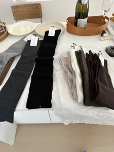 Detail shot of soft over-the-knee socks in multiple solid colors displayed neatly on table.