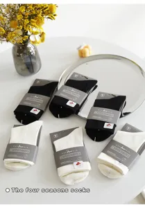 Solid color casual short socks packaged neatly on white table with elegant floral decor.