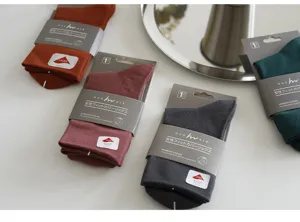 Details of solid color mid tube socks featuring comfortable fabric and neat packaging design.