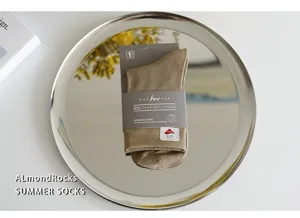 Detail shot of khaki casual socks on metal tray with packaging, soft texture and comfortable fit.
