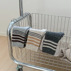 Gros plan de chaussettes en laine rayées automne hiver sur chariot en métal, douce texture tricot.