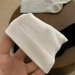 Vue détaillée de chaussettes blanches côtelées, texture douce et confort élastique quotidien.