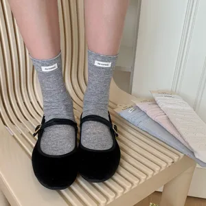 Solid color mesh crew socks with cute cloth label, breathable casual wear for summer daily outfit.
