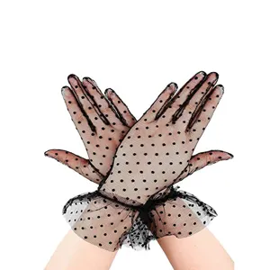 Close-up detail of black polka dot mesh lace gloves, showing delicate frill and fabric.