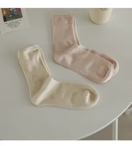 Primo piano di simpatici calzini casual in morbidi colori macaron, stile minimalista accogliente.