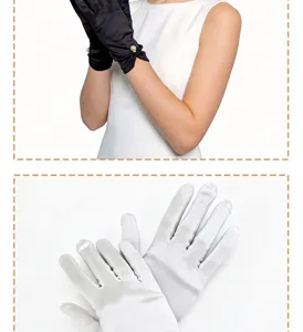 Close-up detail display of short satin bridal gloves in black with pearls and pure white.