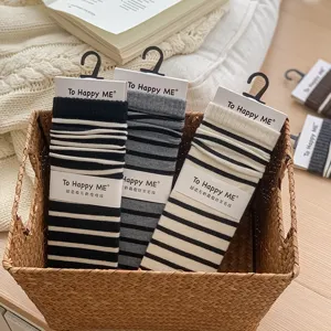 Detailopname van gestreepte slouchy sokken in mand, zachte wol zijde mix textuur.