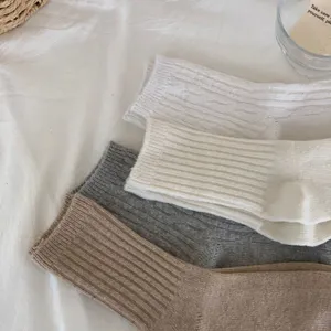 Detailed close-up of cozy winter women's cable knit mid-tube socks in classic solid colors.