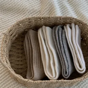 Detailed view of cozy wool blend mid-calf socks in neutral tones, neatly organized in a woven basket.