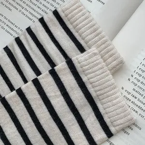 Gedetailleerde close-up van gebreide gestreepte slouch sokken met zachte textuur en stijl.