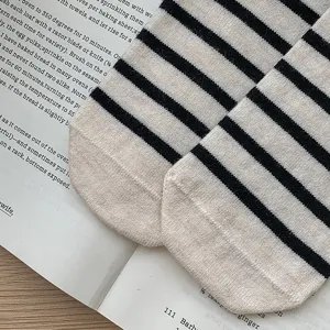 Detailopname van zwart-wit gestreepte gebreide sokken op een mooie boekpagina.