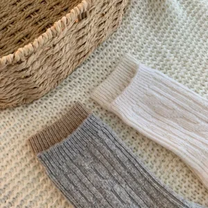 Cozy cable knit wool blend mid-calf socks detail featuring contrasting ribbed cuffs.
