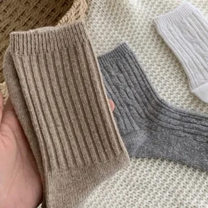 Close-up detail of winter wool cable knit socks showing thick texture and classic solid design.