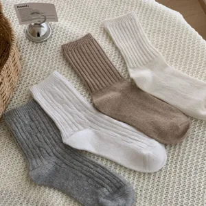 Detailed view of cozy knit crew socks in four warm colors, featuring classic ribbed texture.