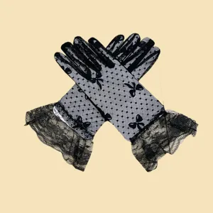 Elegant black lace gloves with polka dots and bows, perfect for summer sun protection.