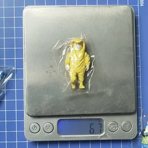 Detaillierte Nahaufnahme der kleinen Schutzanzug-Figur auf einer digitalen Waage.