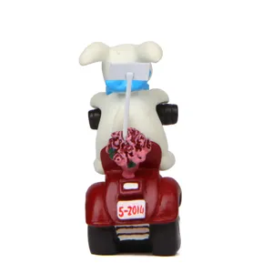 Miniature resin puppy riding red motorcycle figurine detail, cute garden ornament.