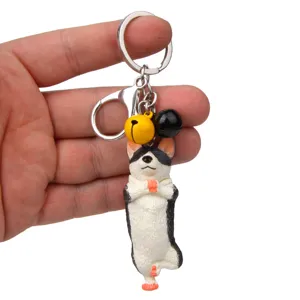 Nahaufnahme Detailansicht des süßen Yoga Hund Schlüsselanhängers mit Glocken und Metallkarabiner.