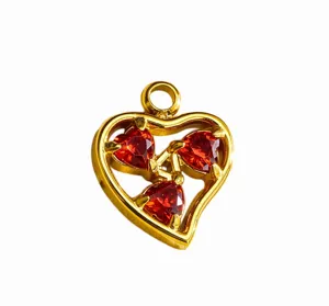 Gold heart pendant detail view with red cubic zirconia stones for DIY jewelry making.