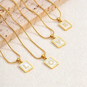 Gouden roestvrijstalen kettingen met witte schelp vierkante letter hangers detail.