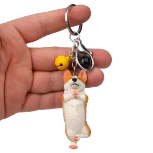 Nahaufnahme eines süßen Yoga Corgi Schlüsselanhängers mit Glocke und Metallkarabiner für Tasche.