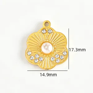 Vue détaillée du pendentif floral doré en acier inoxydable avec des strass et une perle centrale.
