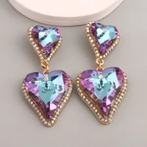 Detail of elegant heart-shaped earrings with purple gradient crystal facets.