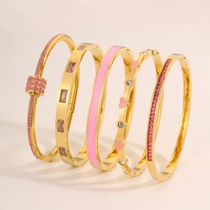 Set mit 5 stilvollen vergoldeten Edelstahl-Armreifen mit pinken Kristallen und Emaille.