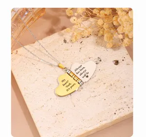 Detail shot of stainless steel love letter heart locket necklace with romantic engraving.