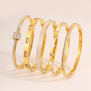 Goldfarbenes Edelstahl Armreif Set mit funkelnden Strasssteinen und eleganten Emaille Details.