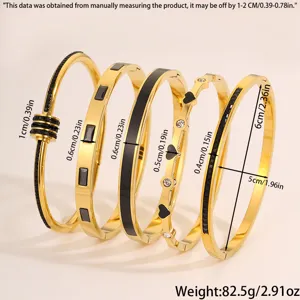 Set aus fünf eleganten goldenen Titanstahl Armreifen mit schwarzen und klaren Zirkonsteinen.