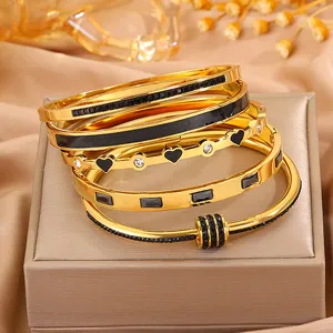 Goldenes Titanstahl Armreif Set mit funkelnden Kristallen und luxuriösem Modeschmuck Design.