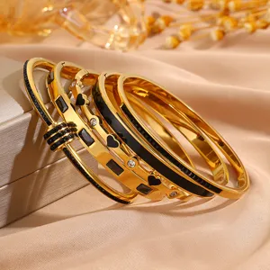 Elegantes Edelstahl vergoldetes Armreif-Set mit schwarzer Einlage und funkelnden Kristallen.