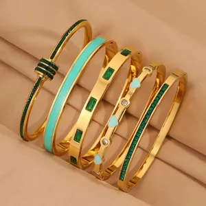 Modische Edelstahl Armbänder Set für Damen, elegante goldene Armreifen mit grünen Kristallen.